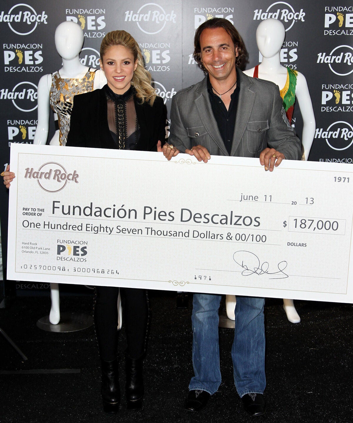 IMAGE DISTRIBUTED FOR HARD ROCK INTERNATIONAL - Area Vice President at Hard Rock International, Tom Perez, right, poses with Fundacion Pies Descalzos founder and singer, Shakira to present a check of over $185,000 towards the Pies Descalzos foundation while on set of NBC’s The Voice, Tuesday, June 11, 2013, in Hollywood, Calif. Money donated to Fundación Pies Descalzos supports efforts to bring higher education and aid to Colombian children and communities in need. (Photo by Matt Sayles/Invision for Hard Rock International / AP Images)