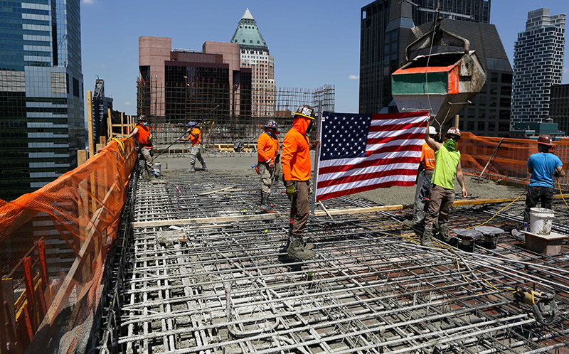 construction workers hoisting american flag